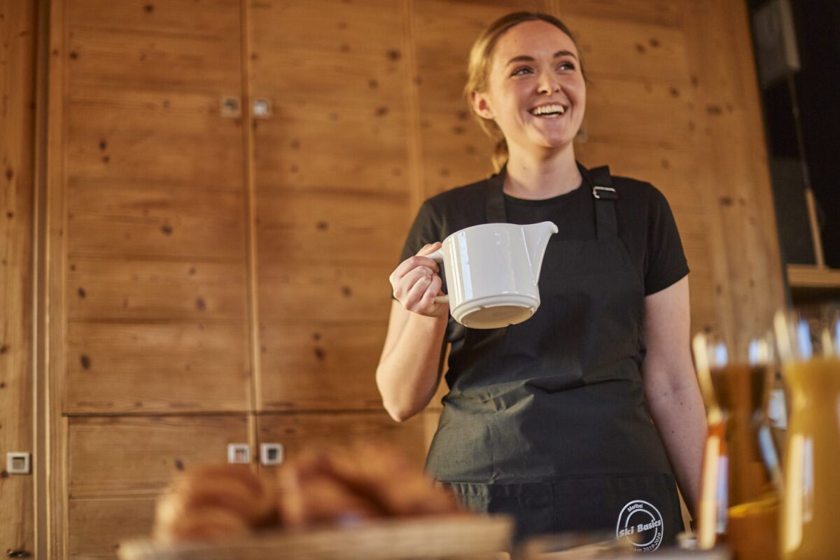 chalet host preparing pot of tea for guests in catered ski chalet